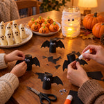 Eltern und Kind basteln Klopapierrollen-Fledermäuse zu Halloween
